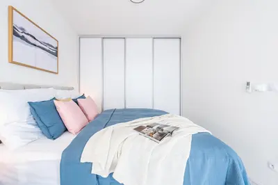 a bedroom with a bed with pink and blue pillows at Prague Days - Family Friendly Two-Bedroom Apartment with AC, Garage and Terrace in Holešovice in Prague