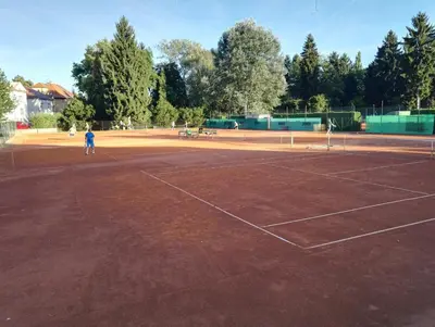 a person standing on a tennis court at Penzion Tenis in Poděbrady