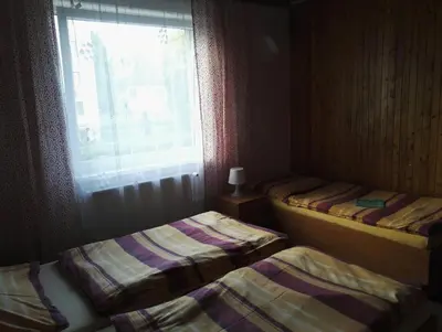 two twin beds in a room with a window at Penzion Tenis in Poděbrady