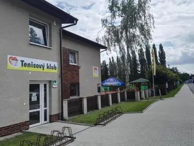 a building with benches parked outside of it at Penzion Tenis in Poděbrady