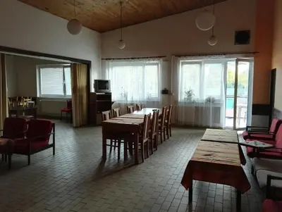 a dining room with tables and chairs and windows at Penzion Tenis in Poděbrady