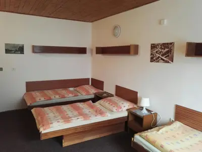 a room with two beds and a table and a lamp at Penzion Tenis in Poděbrady