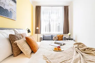 a bedroom with a bed with a plate of food on it at Prague Days - One-Bedroom Apartment with TV, Netflix and High-Speed Wi-Fi in Vinohrady in Prague