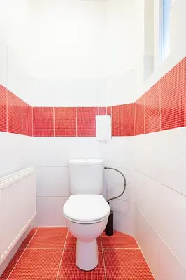 a white toilet in a bathroom with red tiles at Prague Days - One-Bedroom Apartment with TV, Netflix and High-Speed Wi-Fi in Vinohrady in Prague
