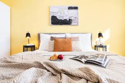 a bed with a book and a plate of food on it at Prague Days - One-Bedroom Apartment with TV, Netflix and High-Speed Wi-Fi in Vinohrady in Prague