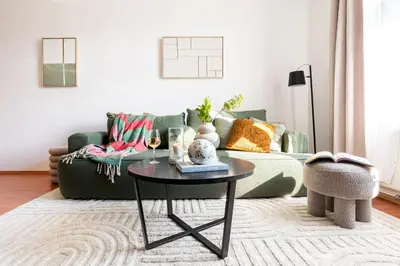 a living room with a green couch and a table at Prague Days - One-Bedroom Apartment with TV, Netflix and High-Speed Wi-Fi in Vinohrady in Prague