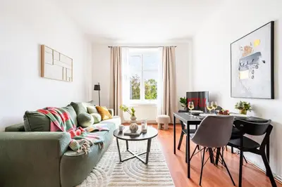 a living room with a couch and a table at Prague Days - One-Bedroom Apartment with TV, Netflix and High-Speed Wi-Fi in Vinohrady in Prague