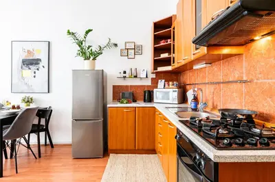 a kitchen with wooden cabinets and a stove top oven at Prague Days - One-Bedroom Apartment with TV, Netflix and High-Speed Wi-Fi in Vinohrady in Prague