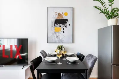 a dining room with a black table and chairs at Prague Days - One-Bedroom Apartment with TV, Netflix and High-Speed Wi-Fi in Vinohrady in Prague