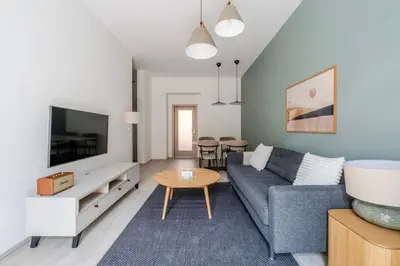 a living room with a blue couch and a table at Blueground Nusle balcony nr Vyšehrad PRG-74 in Prague