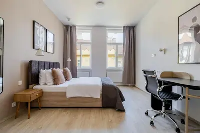a bedroom with a bed and a desk at Blueground Nusle balcony nr Vyšehrad PRG-74 in Prague