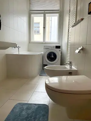 a bathroom with a tub sink and a washing machine at Apartmá in Prague