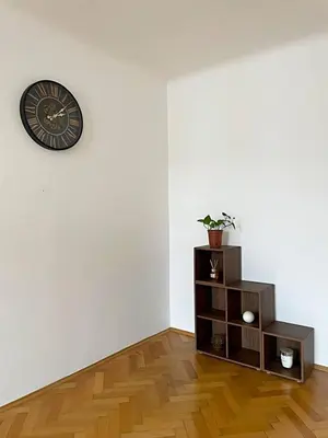 a room with a clock on the wall and a shelf at Apartmá in Prague