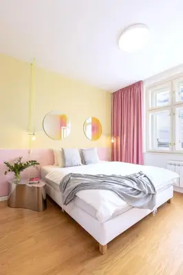 a bedroom with a large white bed and two mirrors at Prague Center Studio in Prague