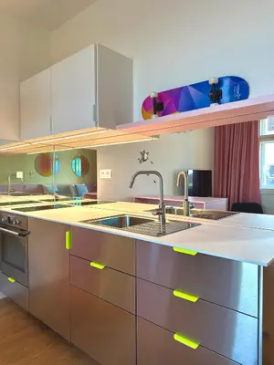 a living room with a pink table and a kitchen at Prague Center Studio in Prague
