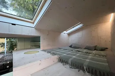 a large bed in a room with a large window at Stylish tiny house in an urban oasis in Prague