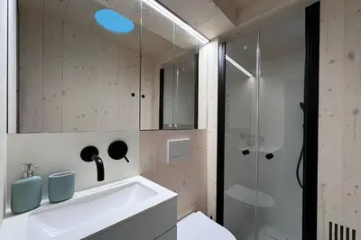 a bathroom with a sink and a glass shower at Stylish tiny house in an urban oasis in Prague