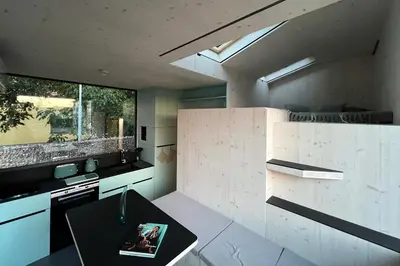 a kitchen with a table in the middle of a room at Stylish tiny house in an urban oasis in Prague