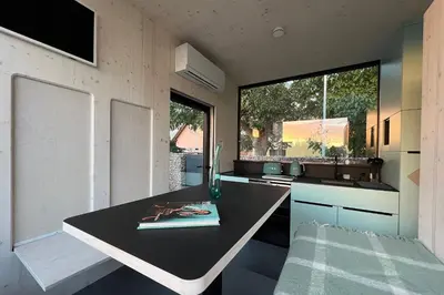 a kitchen with a black counter top and some windows at Stylish tiny house in an urban oasis in Prague