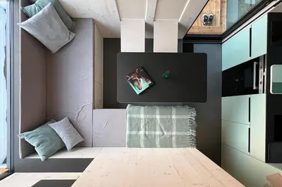 a small room with a bed and a tv on the wall at Stylish tiny house in an urban oasis in Prague