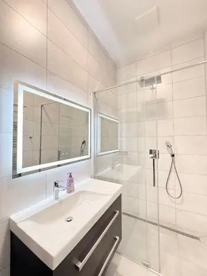 a white bathroom with a sink and a shower at Apartment Old Town Square in Prague