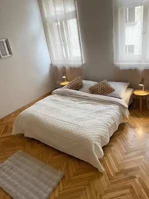 a large bed in a bedroom with two windows at Apartmá ve Středu Prahy in Prague