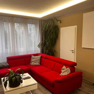 a red couch in a living room with a table at Big apartment in quiet location close to the center -ideal for families with kids in Prague