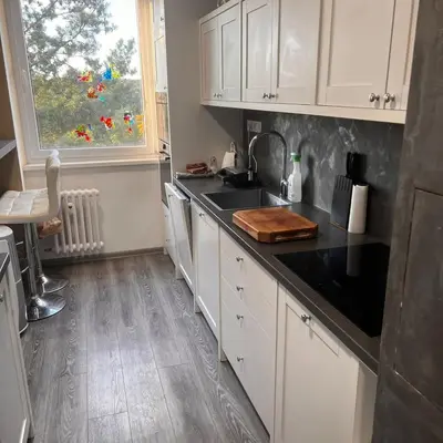 a kitchen with white cabinets and a sink and a window at Big apartment in quiet location close to the center -ideal for families with kids in Prague