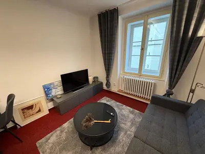 a living room with a couch and a table at Romantic Apartment in historical house from 1398 in Prague city centre in Prague