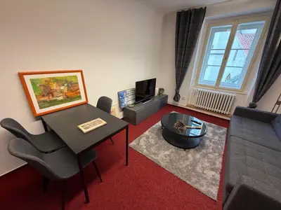 a living room with a table and a couch at Romantic Apartment in historical house from 1398 in Prague city centre in Prague