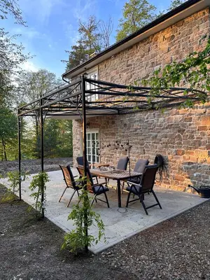 a patio with a table and chairs in front of a brick building at Nad svatým Kiliánem