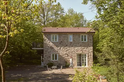 a man standing in front of a stone house at Nad svatým Kiliánem