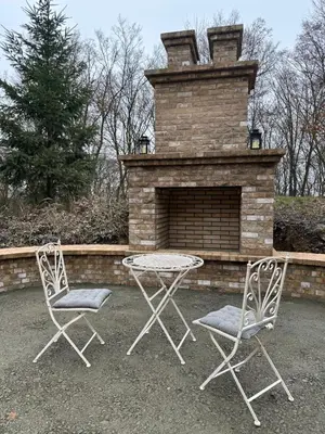 two chairs and a table in front of a brick fireplace at Nad svatým Kiliánem