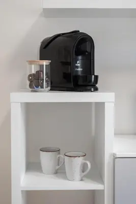 a coffee maker and two cups on a shelf at Bella Vita in Prague