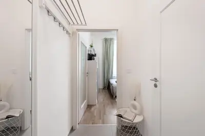 a white bathroom with white walls and a hallway at Bella Vita in Prague