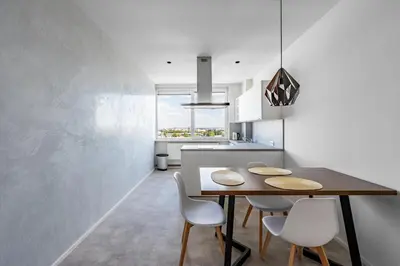 a kitchen with a wooden table and white chairs at Urban Oasis Stodůlky in Prague