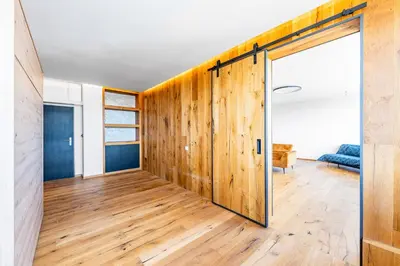 an open sliding door in a room with wooden floors at Urban Oasis Stodůlky in Prague