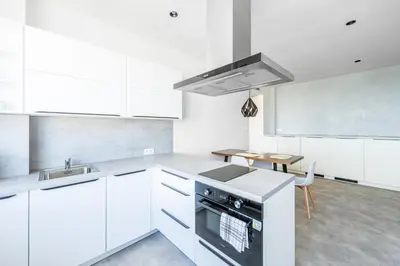 a kitchen with white cabinets and a stove top oven at Urban Oasis Stodůlky in Prague