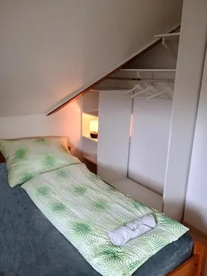 a bed with a green and white comforter in a room at Ubytování nad kostelem in Prague