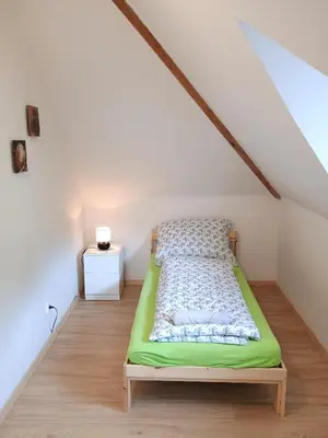 a bedroom with a green bed in a attic at Ubytování nad kostelem in Prague