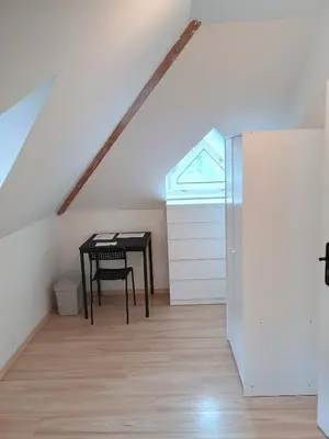 a room with a table and a refrigerator in a attic at Ubytování nad kostelem in Prague