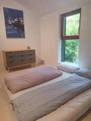 a bedroom with a bed and a dresser and a window at Romantický domek Slapy
