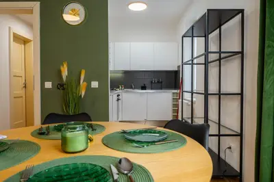 a dining room with a table and a kitchen at The Green Loft Studio - 10 min to City Center in Prague