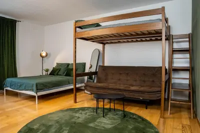 a living room with a bunk bed and a couch at The Green Loft Studio - 10 min to City Center in Prague