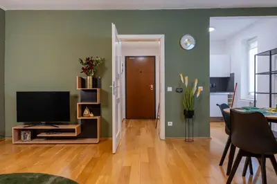 a living room with a television and a dining room at The Green Loft Studio - 10 min to City Center in Prague