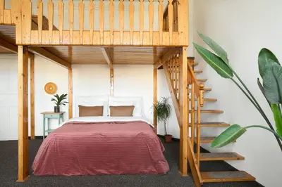 a bedroom with a loft bed and a staircase at Muze Suites in Prague