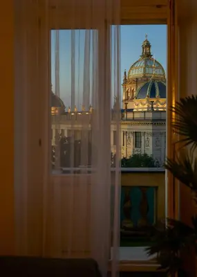 a room with a desk and a window with a building at Muze Suites in Prague