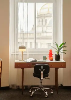 a desk with a chair in front of a window at Muze Suites in Prague