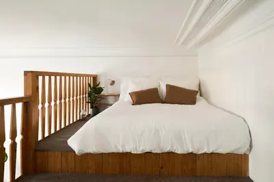 a bedroom with a bed with white sheets and brown pillows at Muze Suites in Prague