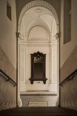 an archway in a building with a window with a clock at Muze Suites in Prague